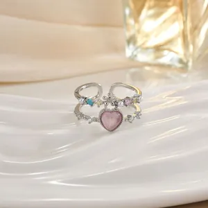 Dettaglio macro di un anello a doppio strato con cuore rosa, perle e pietre miste