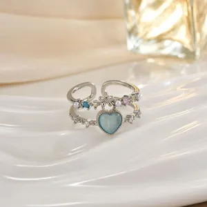 Dettaglio anello in argento con pietra occhio di gatto blu a cuore e perle