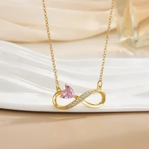 Detailaufnahme der goldenen Infinity-Halskette mit rosa Herzstein und Pavé-Zirkon-Besatz