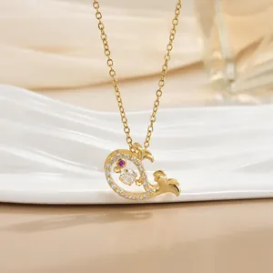 Macro detail of whale tail pendant in gold with sparkling zircons and a purple gem