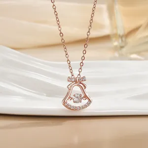 Makro-Detail des Roségold-Glockenanhängers mit schimmernden Diamanten und Schleife an Kette
