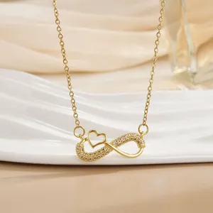 Detailansicht der goldenen Infinity-Herz-Halskette mit Zirkonia auf weißem Ständer