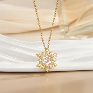 Detailed view of a gold snowflake pendant necklace with sparkling inlaid diamonds