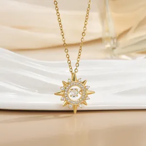 Detail of gold sun star pendant with sparkling cubic zirconia on white ceramic base