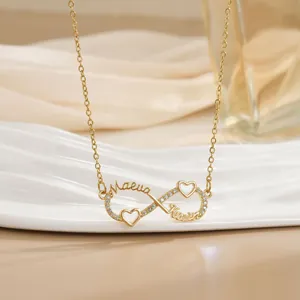 Detail der Infinity-Halskette mit Namen und zirkonbesetzten Herzen in Gold-Optik