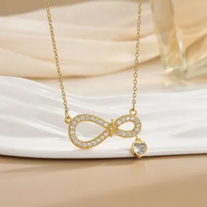 Detail der goldenen Infinity-Halskette mit Herz-Edelstein auf Seidenhintergrund