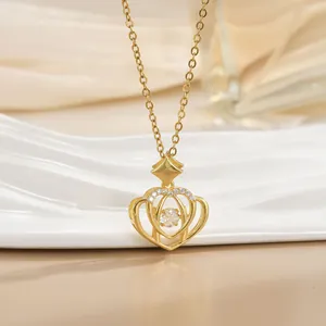 Detailed view of a gold crown pendant necklace with sparkling white cubic zirconia stones