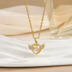 Detailed close-up of a gold heart necklace with sparkling wings on a luxury display
