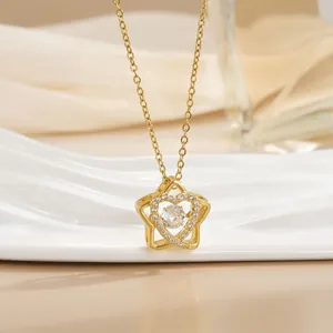 Detail shot of a star-shaped necklace with a dancing heart diamond pendant in gold finish
