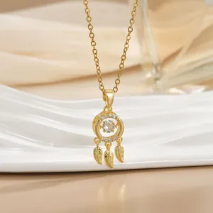 Macro detail of gold dreamcatcher necklace featuring sparkling zircons and delicate leaf pendants