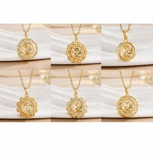 Detail shot of golden rotatable windmill necklaces with white zircon insets and cross chain
