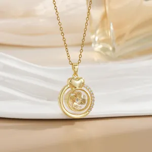 Detail of a rotating golden windmill pendant with small zircon stones and heart charm