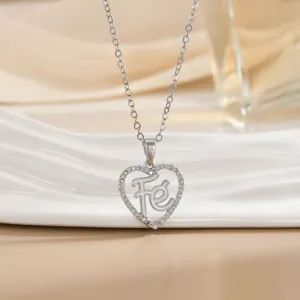 Macro detail of silver heart pendant featuring micro-paved zircons and Fé engraving
