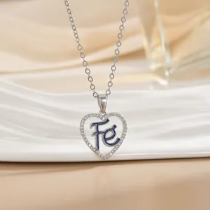 Macro shot of silver heart pendant with blue enamel, Fe letter and zircon inlay
