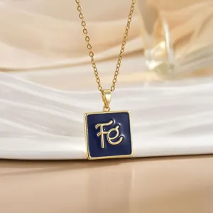 Close-up of golden cross chain with blue enamel square pendant featuring Fé engraving