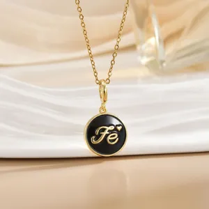 Macro detail of gold disk pendant with black enamel inlay and Fe engraving