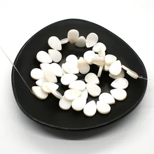 Natural teardrop white shell beads for DIY jewelry making displayed on a black ceramic tray