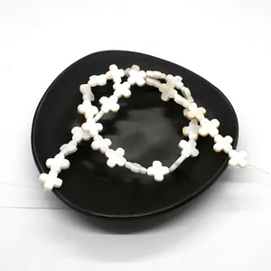 Macro view of natural white shell cross-shaped beads with pearlescent luster for DIY jewelry