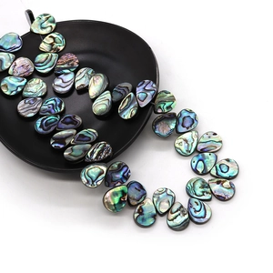 Polished teardrop abalone shell beads with natural iridescent colors on black tray