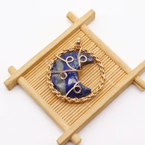 Macro detail of handmade gold wire-wrapped round pendant with crescent blue lapis stone