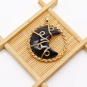 Macro view of wire-wrapped crescent moon stone pendant with golden braided frame