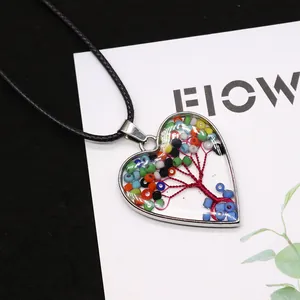 Macro view of heart-shaped Tree of Life pendant with colorful beads on black cord