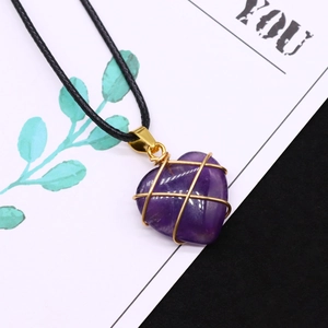 Detailansicht des herzförmigen Amethyst-Anhängers mit Golddrahtwicklung und Kordel