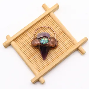 Detailweergave van handgemaakte amethist hanger met abalone schelp en koperen omlijsting