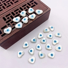 Macro view of heart-shaped evil eye shell beads inside a vintage wooden jewelry box