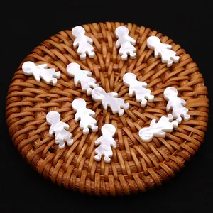 Set de 12 cuentas de nácar natural con forma de niña sobre una bandeja para joyería DIY