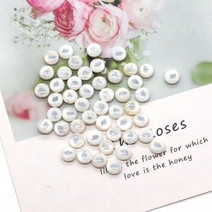 Macro view of round pearl shells with silver cloud pattern on floral background