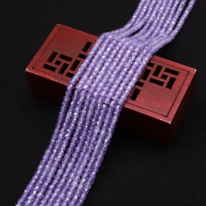 Gros plan de perles en zircone violette facettée sur un coffret en bois de rose chinois