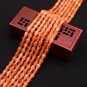 Macro shot of faceted orange cat-eye stone beads in teardrop shape for DIY jewelry making