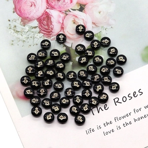 Detailed macro view of black shell beads featuring golden cross patterns for DIY jewelry