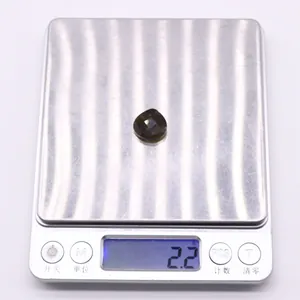Macro view of a 2.2g faceted teardrop natural stone pendant on a digital scale