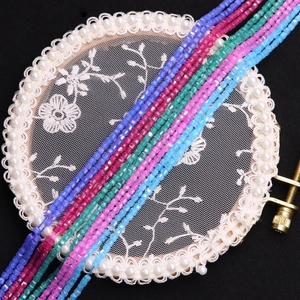 Colorful faceted square zircon beads for DIY jewelry making on white lace and black background