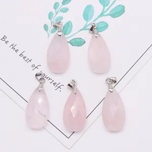 Close-up of five faceted rose quartz teardrop pendants with silver bails on a white card