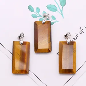 Three rectangular tiger eye stone pendants with silver clasps on an aesthetic background