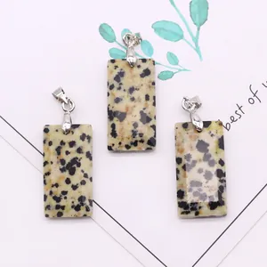 Macro view of rectangular Dalmatian Jasper stone pendants with silver metal clasps
