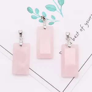 Three pieces of rectangular rose quartz pendants with silver metal clasps on a white card
