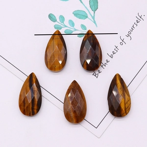 Detailed view of faceted tiger eye stones in teardrop shape with natural brown textures