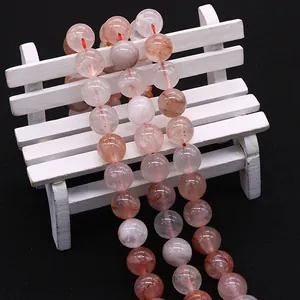 Natuurlijke rode hematoïde kwarts kristallen ronde kralen op een wit decoratief bankje