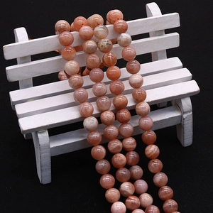 Perle di pietra del sole arancione naturale per gioielli fai da te su sedia bianca mini