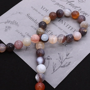 Polished Persian Gulf Agate round beads for DIY jewelry making on a dark background