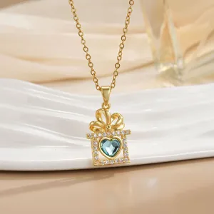 Detail of a 18k gold plated necklace featuring a blue heart gem in a gift box pendant