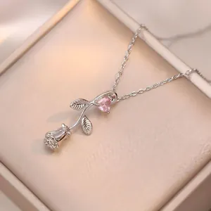 Vue macro d'un collier pendentif rose argentée avec zircon cœur rose dans un coffret cadeau