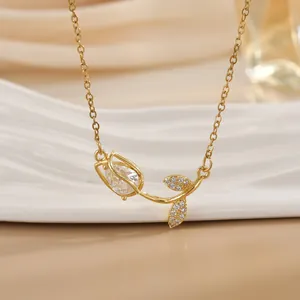 Elegante goldene Tulpen-Halskette mit birnenförmigem Zirkon auf weißem Keramiktablett