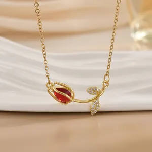 Makroaufnahme der goldenen Tulpen-Halskette mit rotem Edelstein und Zirkonia-Blättern