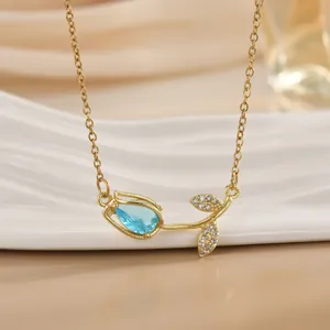 Detailaufnahme der goldenen Tulpen-Halskette mit blauem Tropfenstein und Zirkonia-Blättern