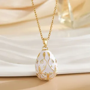 Detail of Fabergé style egg pendant with white enamel, floral gold filigree and crystals